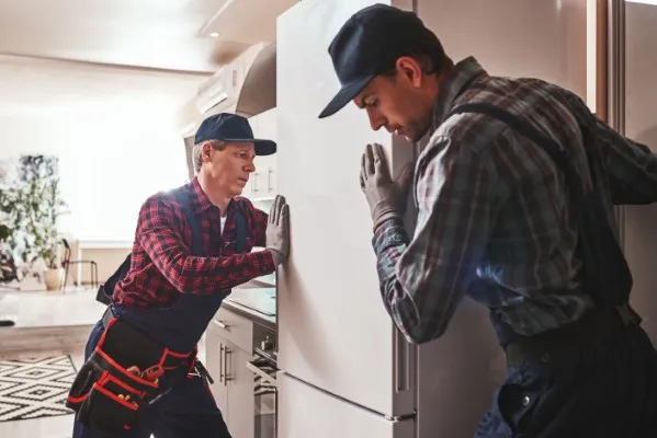 Hombres reparsndo un refrigerador