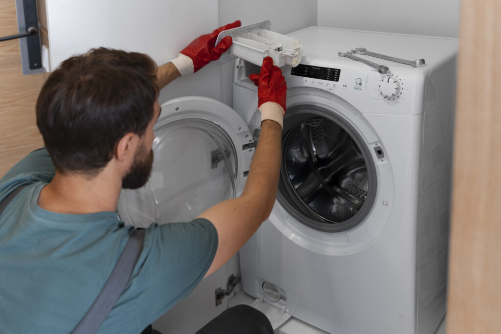 Profesional de reparación de lavadoras en Coyoacán retirando cajón de detergente para limpieza técnica de sarro